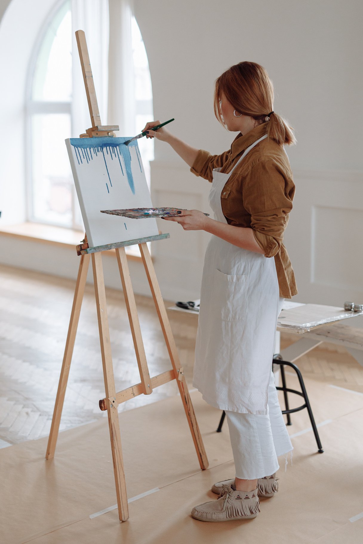 Woman in Brown Long Sleeves Painting on a Canvas